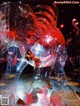 A woman in a red dress is sitting inside of a glass sculpture.