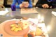 A woman sitting at a table with a plate of food on it.