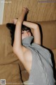 A woman laying on top of a couch covered in a blanket.