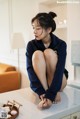 A woman sitting on top of a kitchen counter next to a sink.