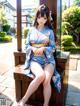 A woman in a blue kimono sitting on a wooden bench.