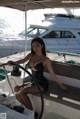 A woman sitting at the helm of a boat in the water.