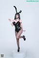 A woman in a black bunny costume posing for a picture.