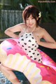 A woman in a bathing suit sitting on an inflatable donut.