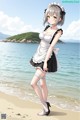 A woman in a maid outfit standing on a beach.