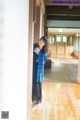 A woman standing in a room with a wooden floor.