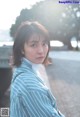 A woman in a blue and white striped shirt is posing for a picture.