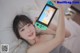 A woman laying on a bed holding a Nintendo Switch.