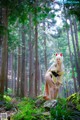 A woman in a kimono is standing in the woods.