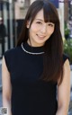 A woman in a black dress posing for a picture.